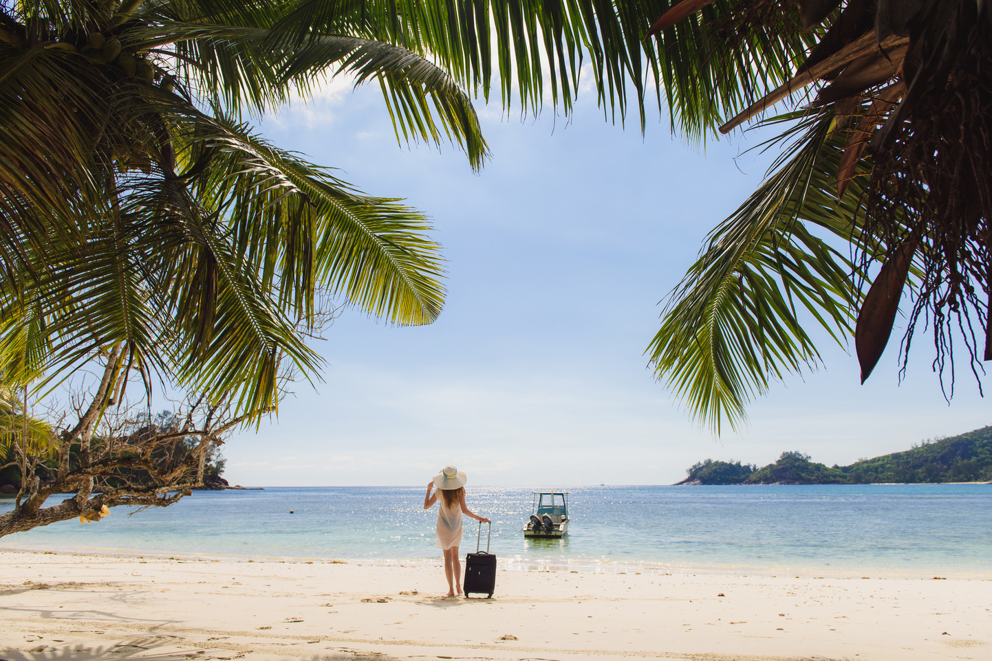 Girl with a suitcase on the beach